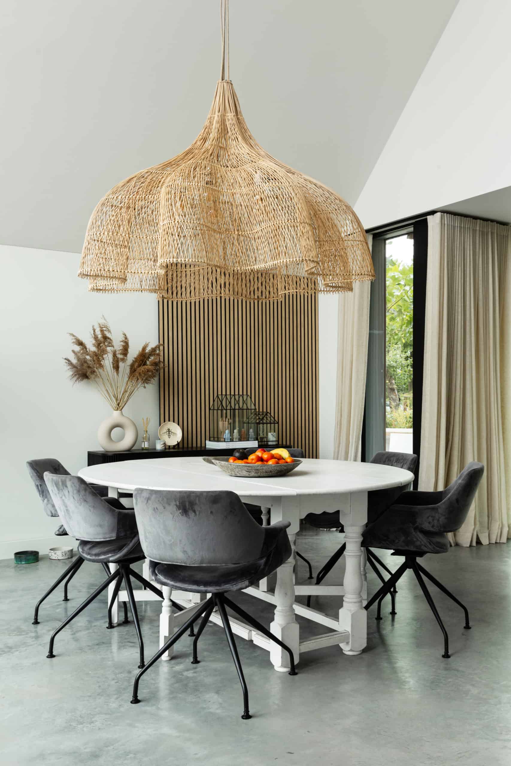 Woning in Nuenen met een gevlinderde betonvloer van Willem Designvloeren. Hierop staat een witte eettafel met daaraan grijze stoelen. Ook staat er een wit kookeiland op de gevlinderde betonvloer.