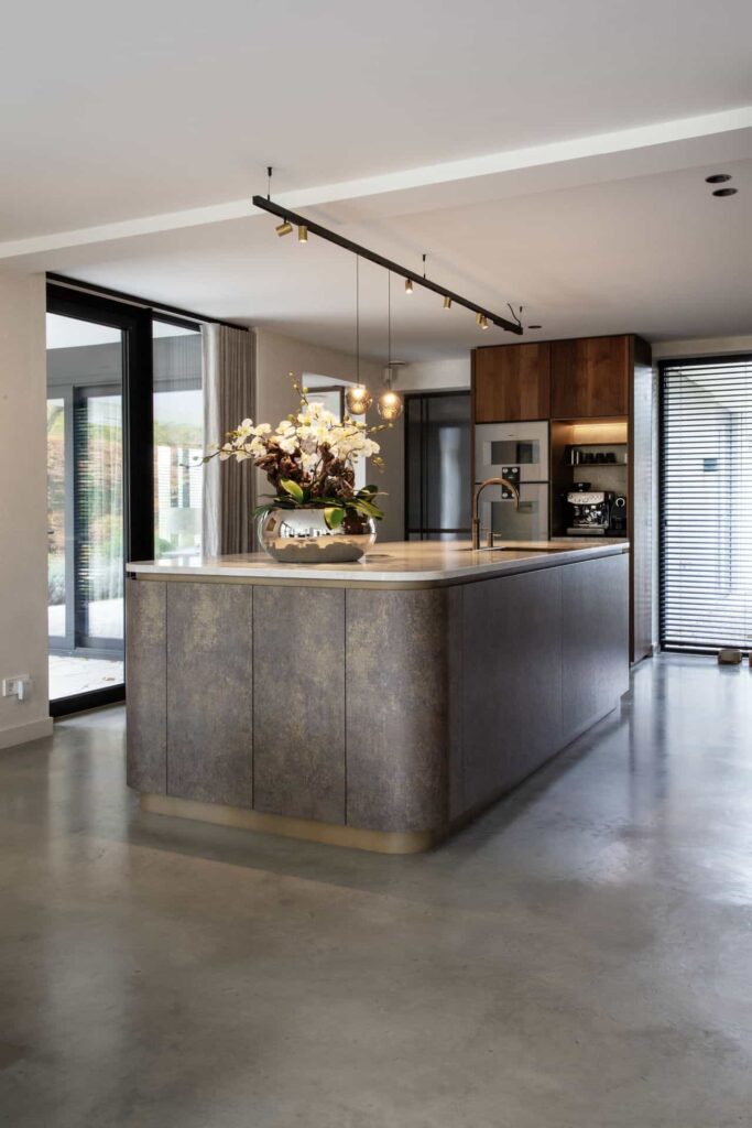 Roestkleurig keukeneiland op een gevlinderde betonvloer in Waalwijk.