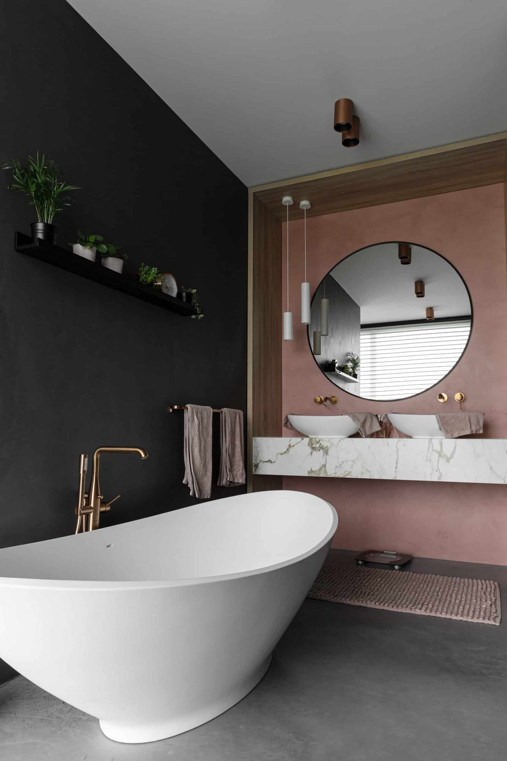 Badkamer met een gevlinderde betonvloer en beton ciré wanden in een antraciete en roze kleur in Bunschoten-Spakenburg.