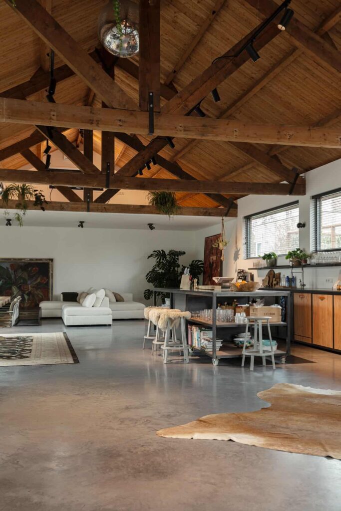 De keuken en woonkamer zijn gecombineerd in één grote open ruimte die voorzien is van een betonnen vloer.