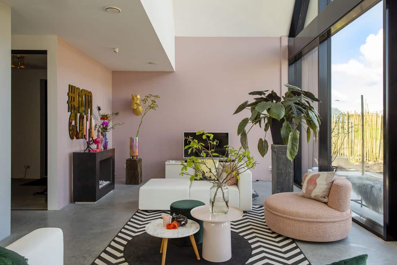 Eclectische woonkamer in Schoonhoven met een gevlinderde betonvloer van Willem Designvloeren gecombineerd met veel kleur en prints.