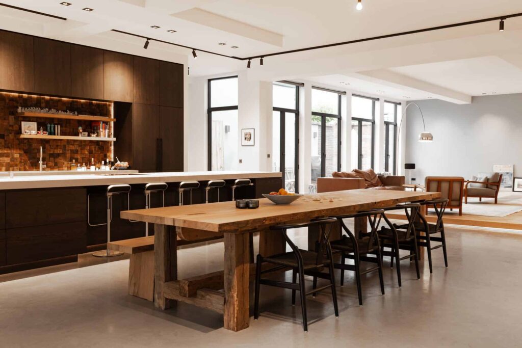 Gevlinderde betonvloer in Den Haag. Deze ligt in de keuken. De keuken is bruin en er staat een kookeiland met 5 barkrukken.