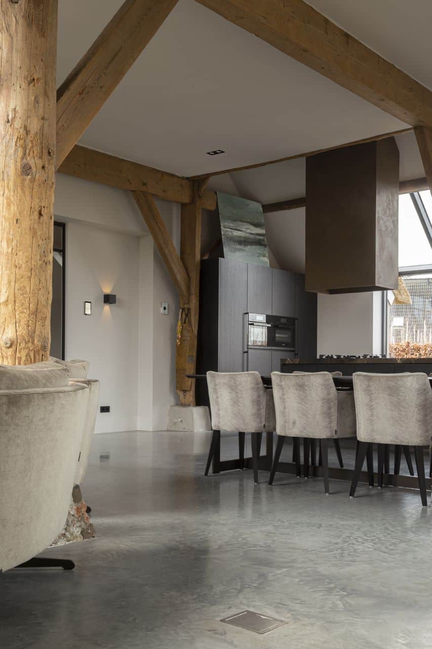 Gevlinderde betonvloer in Ochten gecombineerd met zwarte en grijze meubels.