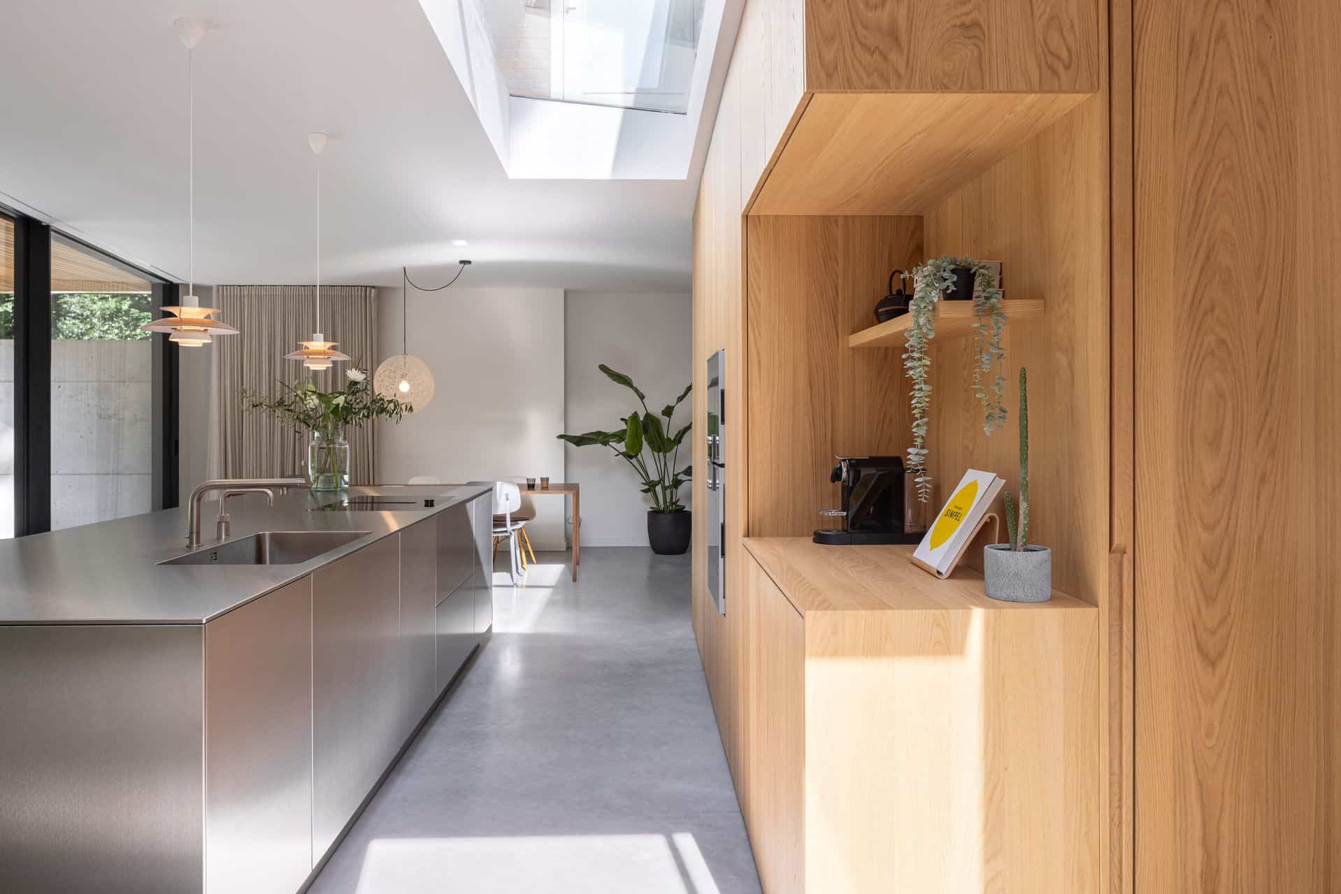 Gevlinderde betonvloer in Zeist met daarop een houten keuken en een RVS kookeiland