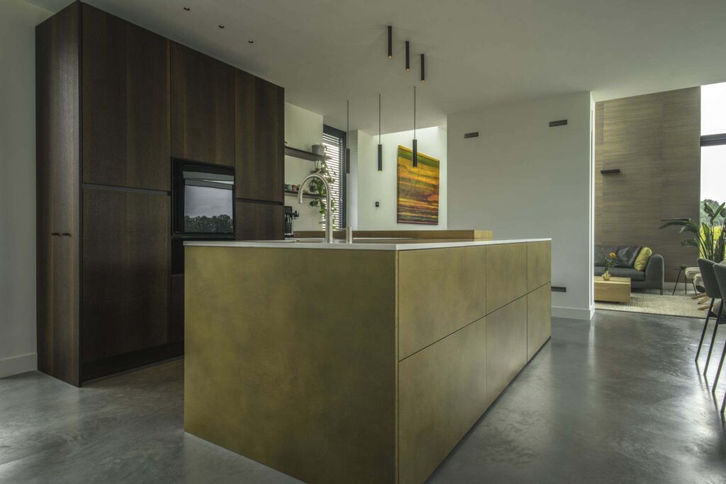 Gevlinderde betonvloer in een woning in Wijhe met daarop een bruine keuken en kookeiland.