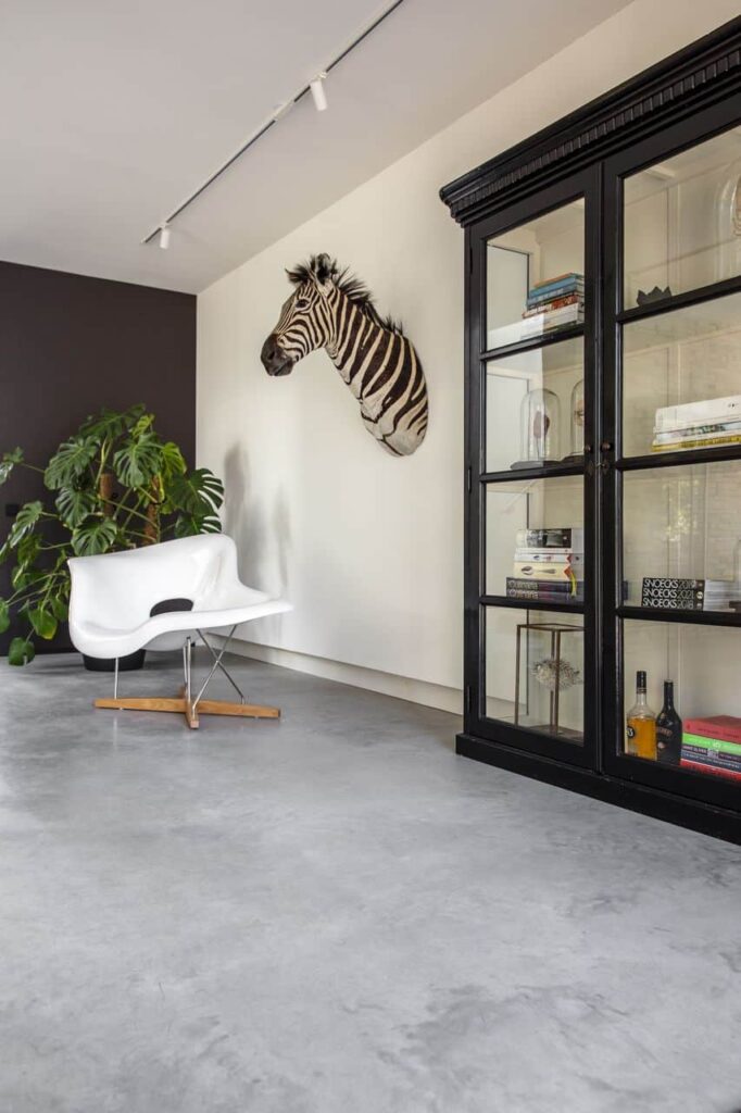 Gevlinderde betonvloer van Willem Designvloeren in Nijmegen. Aan de wand hangt een hoofd van een zebra.