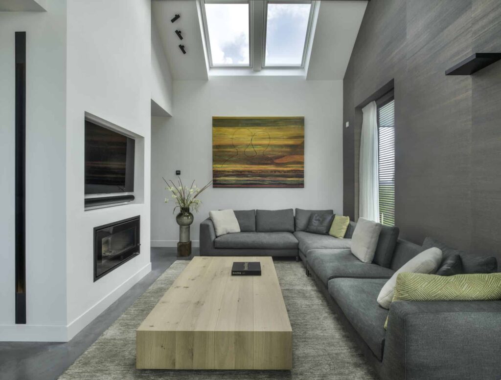 Gevlinderde betonvloer van Willem Designvloeren in een woning in Wijhe met daarop een grijze bank, een vloerkleed en een houten salontafel.