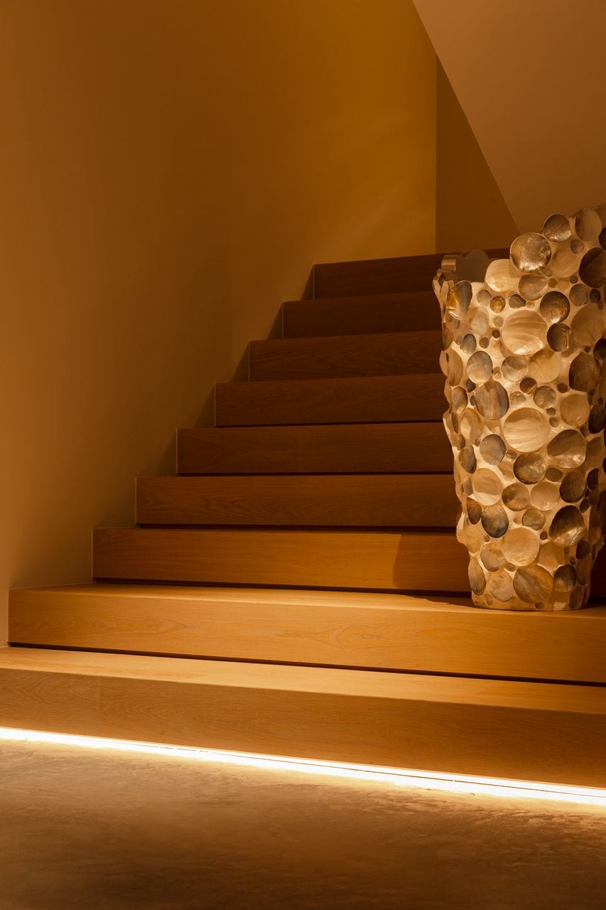 Gevlinderde woonbeton vloer gecombineerd met een prachtige, grote houten trap naar boven.