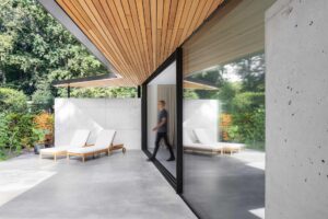 Gevlinderde woonbeton vloer in Zeist die doorloopt naar het gevlinderde betonnen terras. Op het terras staan twee ligstoelen.