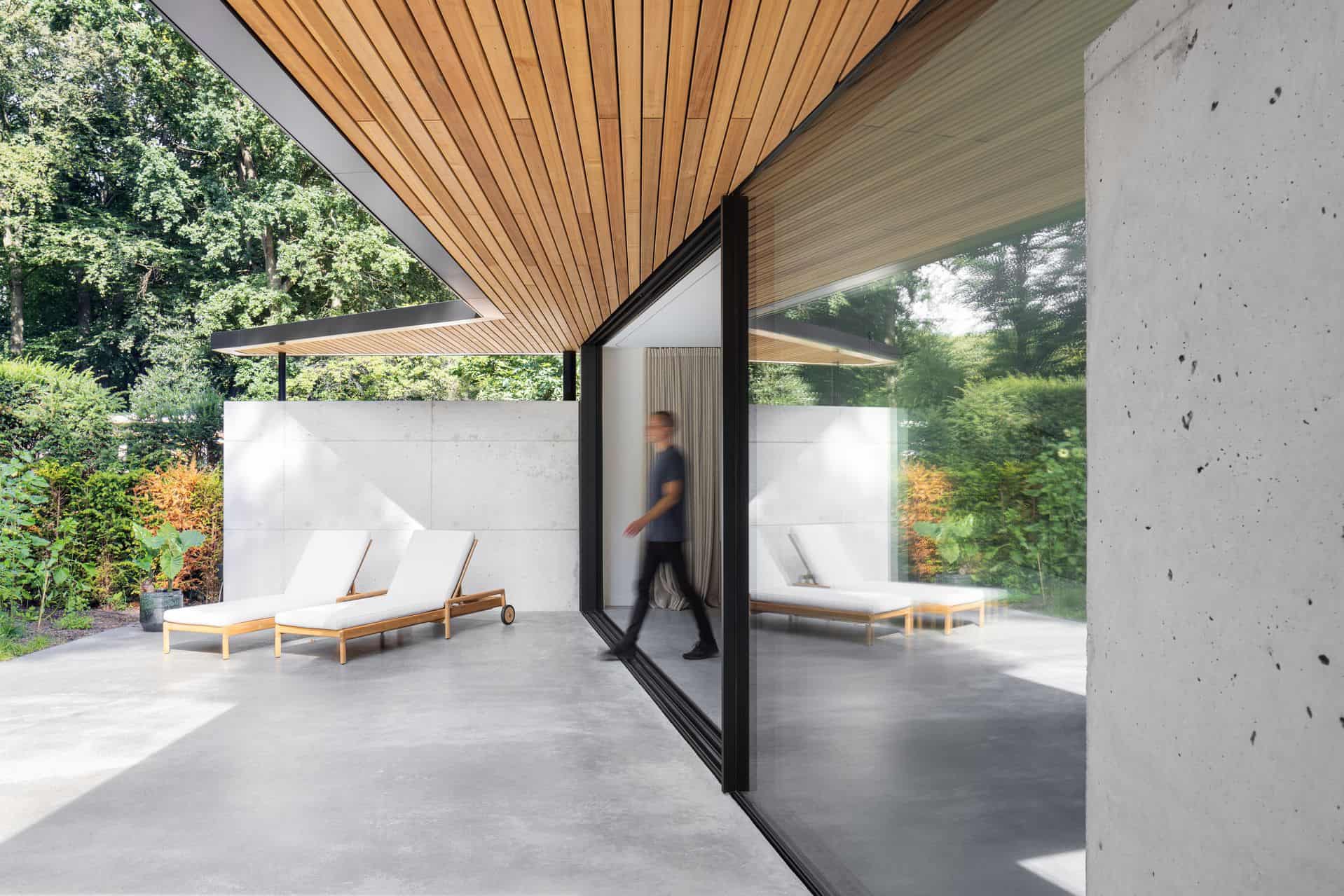 Gevlinderde woonbeton vloer in Zeist die doorloopt naar het gevlinderde betonnen terras. Op het terras staan twee ligstoelen.