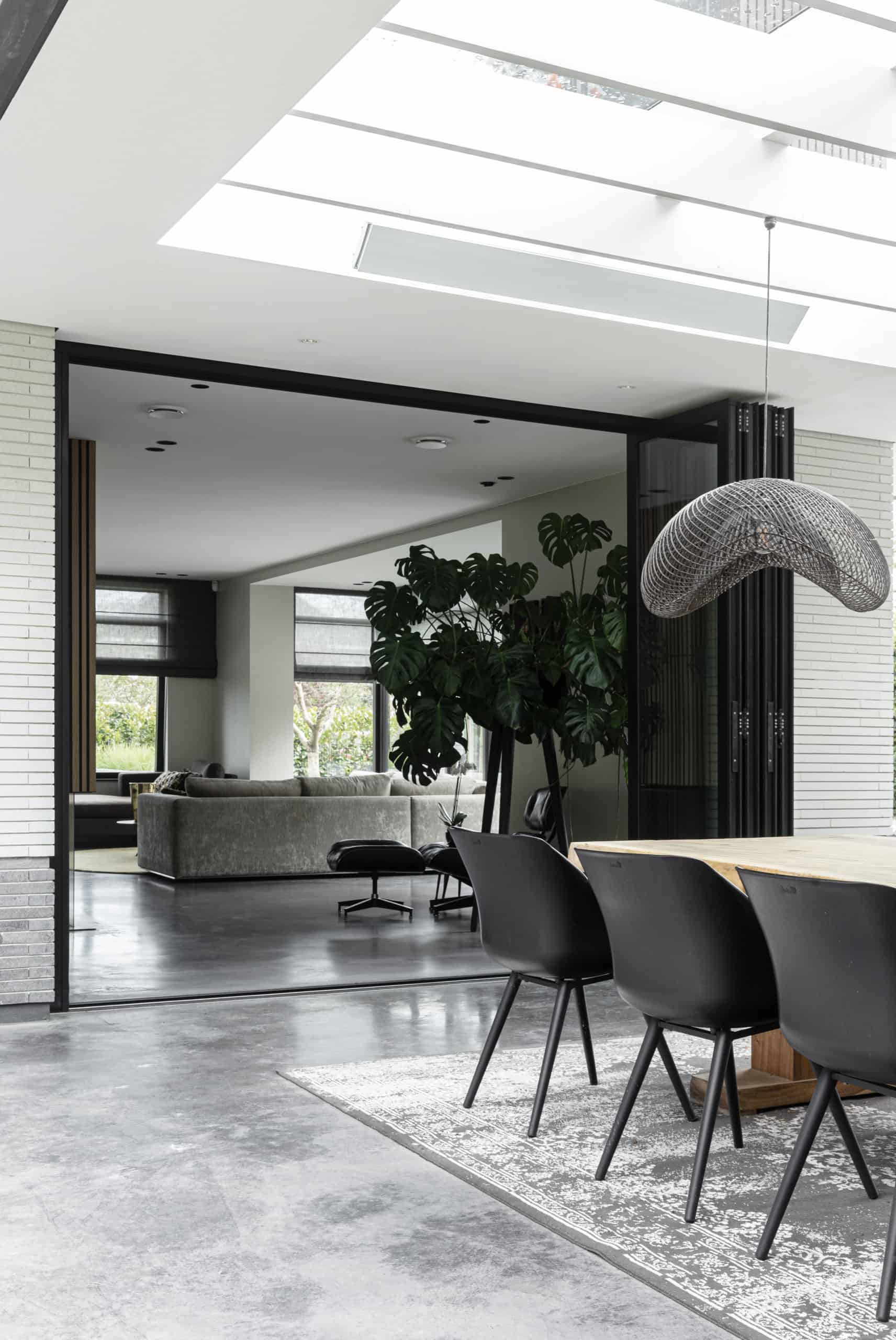 Overloop van het gevlinderd betonnen terras naar de gevlinderde betonvloer in huis.