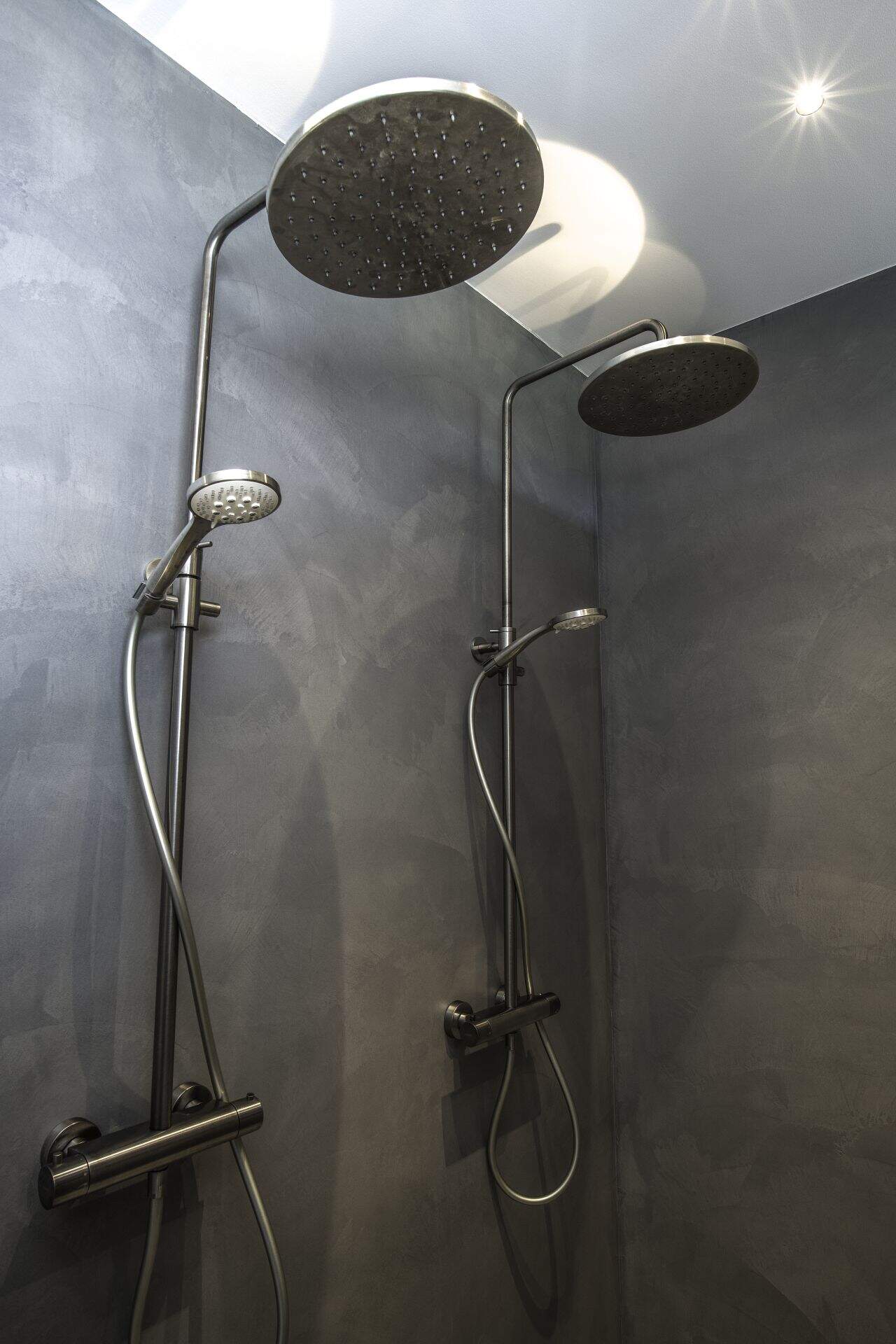 Woning in Wijhe met een gevlinderde betonvloer en beton ciré wanden in de badkamer. In de badkamer is een dubbele douche geplaatst.