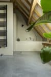 Beton ciré muur in de badkamer. Gevlinderde woonbeton vloer in de badkamer.