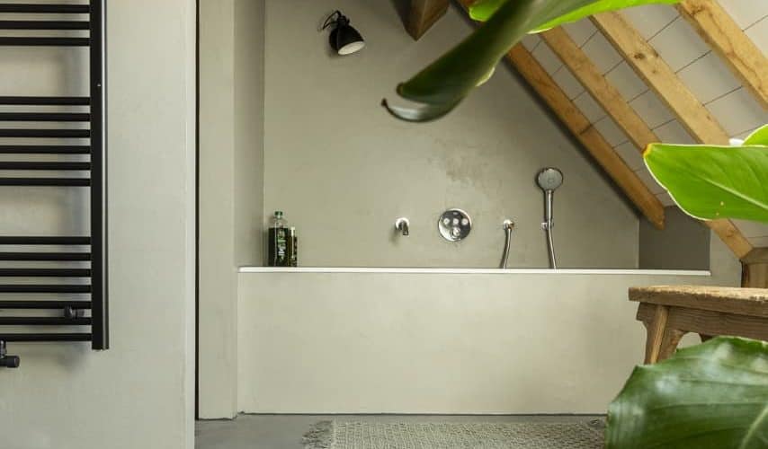 Beton ciré muur in de badkamer. Gevlinderde woonbeton vloer in de badkamer. Beton cire kleur