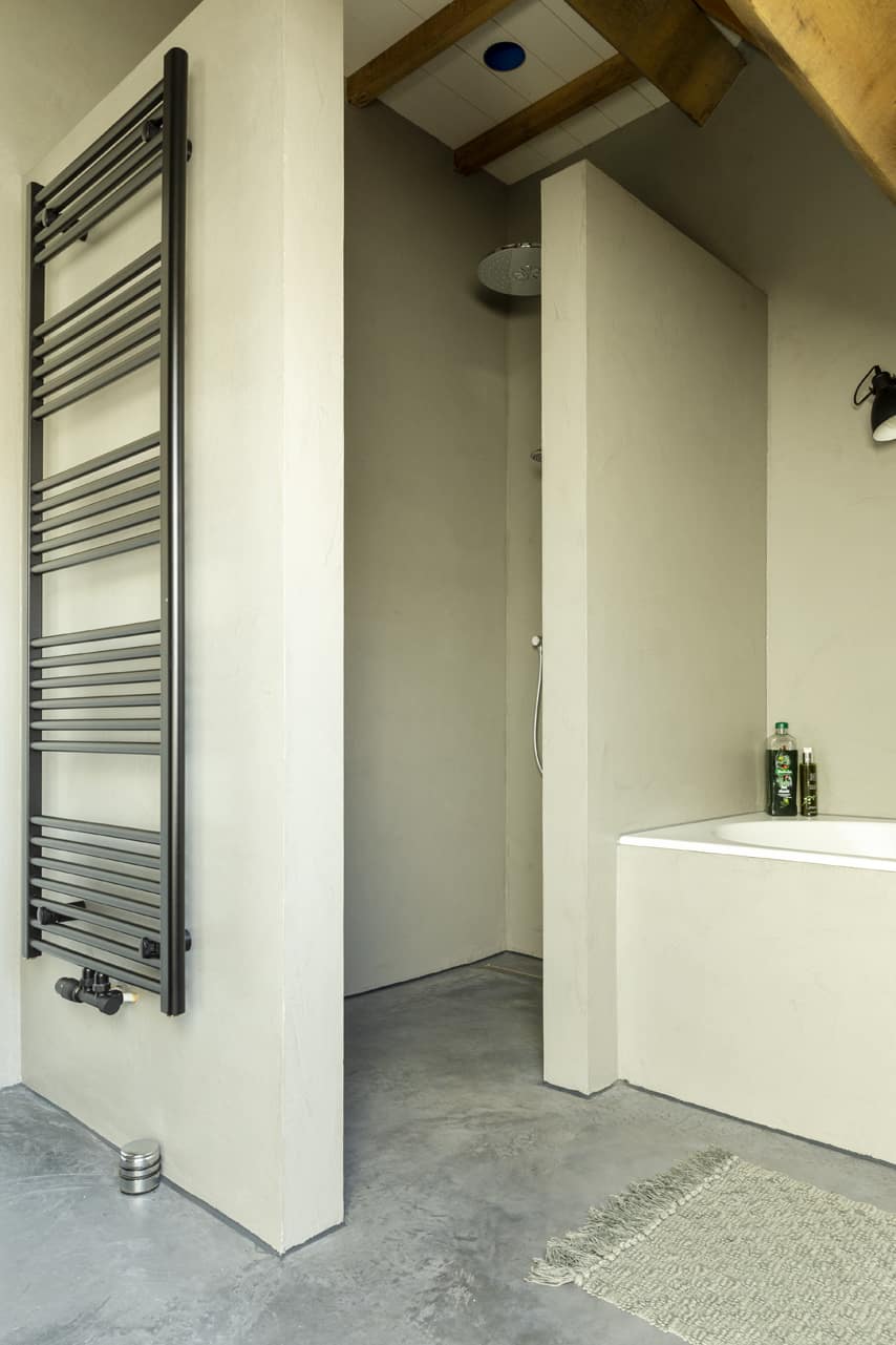 Badkamer met een gevlinderde betonvloer en een beton ciré muur.