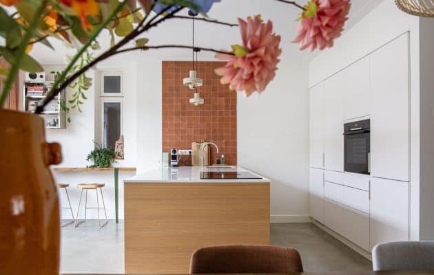 Modern vintage interieur gecombineerd met oranje tegels, een witte keuken en een grijze naadloze vloer van Willem Designvloeren.
