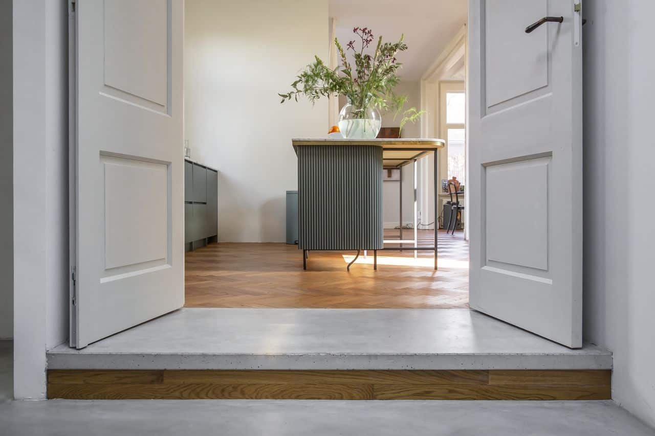 beton combineren met hout, gekleurde keuken met houten visgraat vloer en gevlinderde betonvloer van Willem Designvloeren