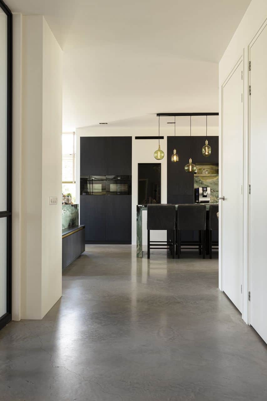 Keukeninspiratie: gevlinderde betonvloer met zwarte eiken keuken en groen marmer werkblad