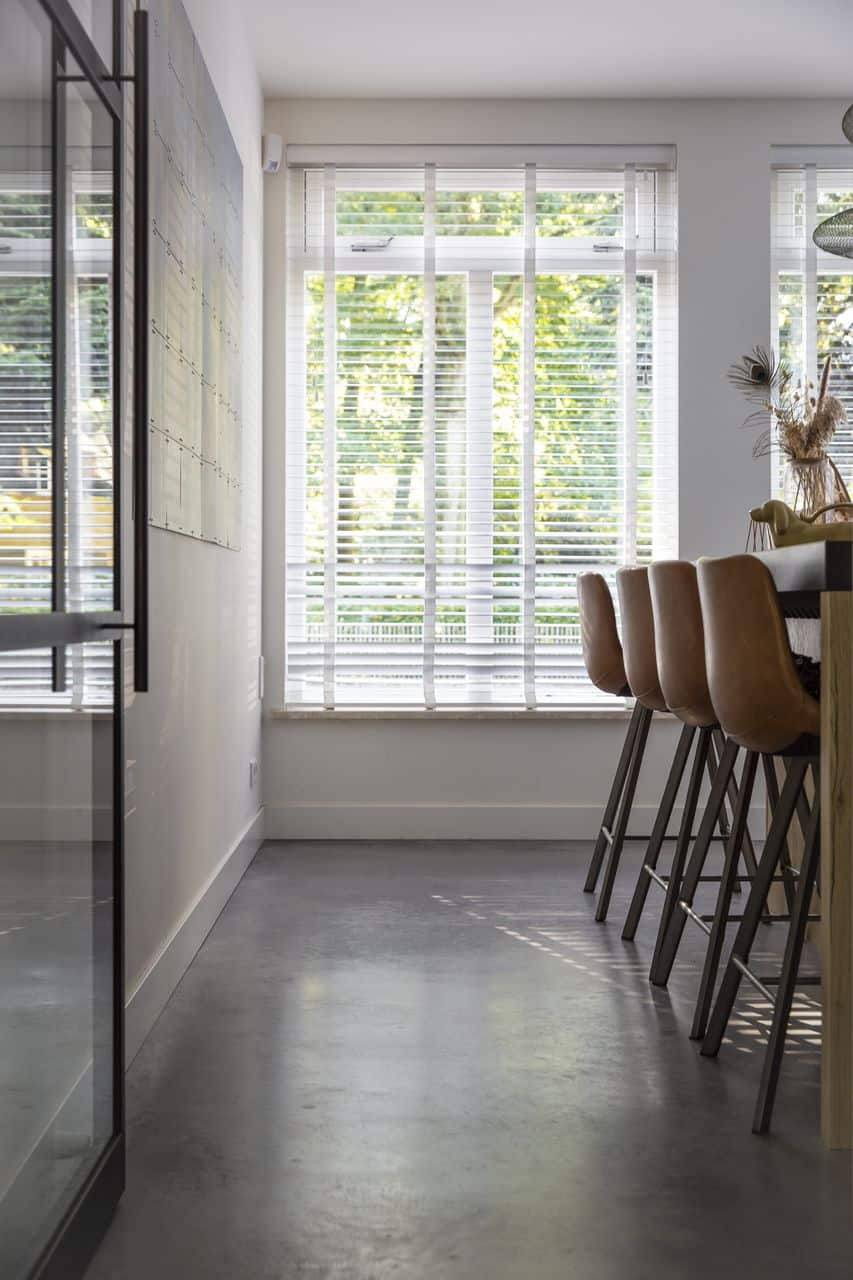 Gevlinderde betonvloer in de keuken gecombineerd met cognac leren stoelen