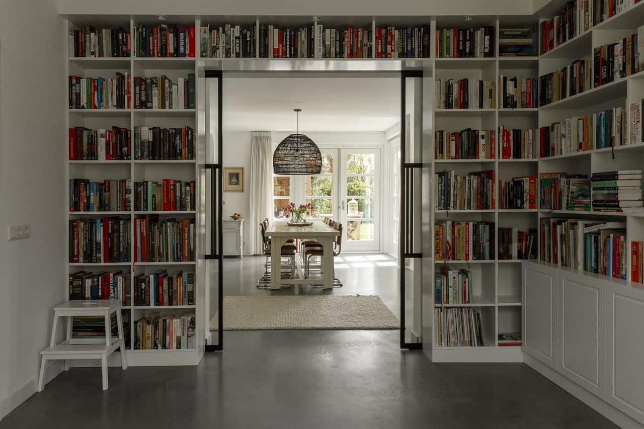 Grijze gevlinderde betonvloer in combinatie met een grote boekenkast