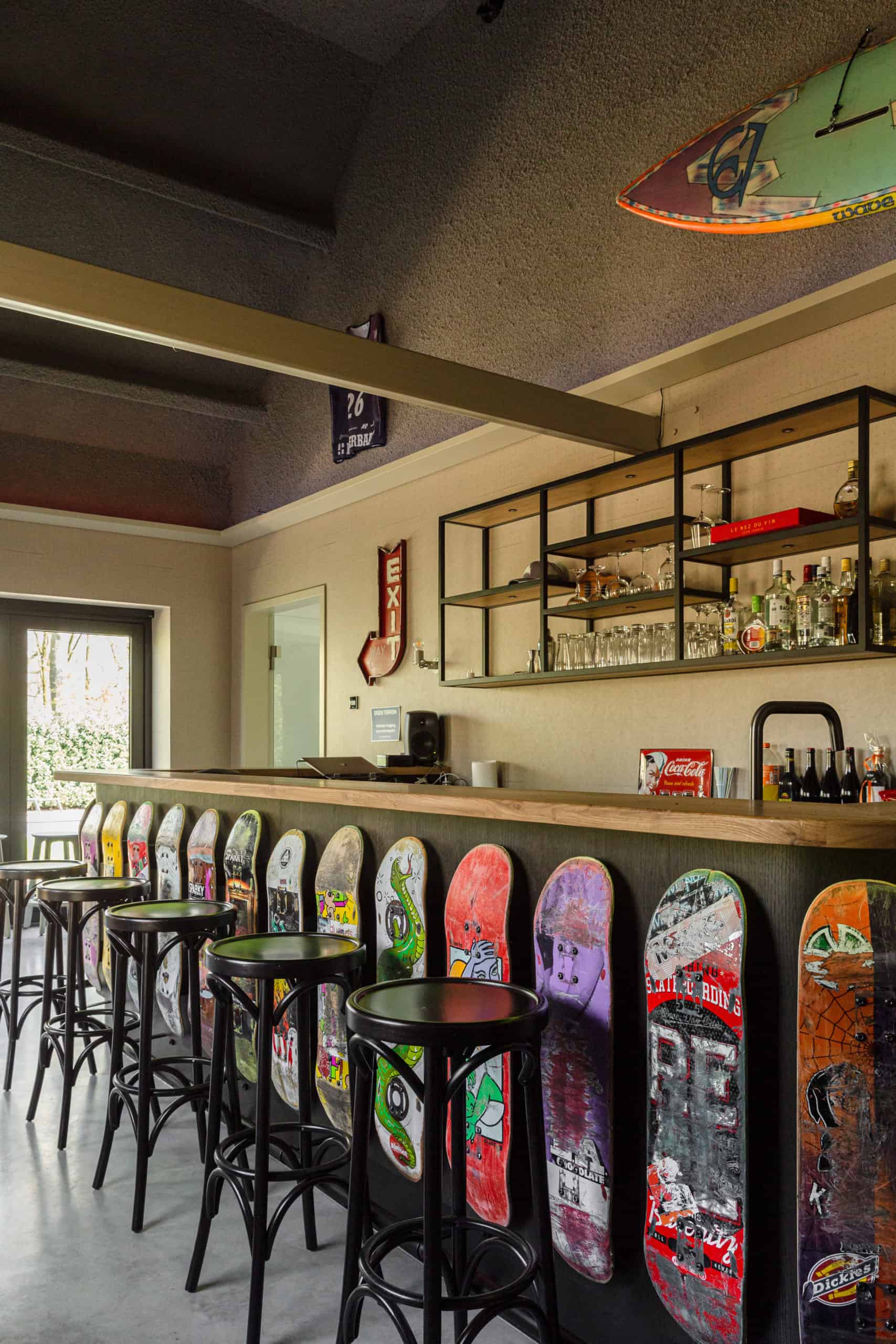 Bar in Oss omringd door skateboards gecombineerd met een gevlinderde betonvloer van Willem Designvloeren
