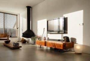 Italiaanse betonlook vloer in de woonkamer in Oostzaan gecombineerd met houten meubels en een zwarte haard.