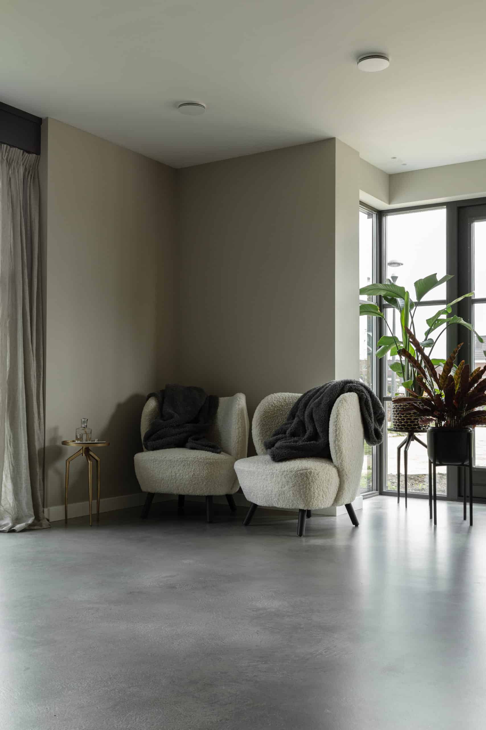 Twee grijze stoelen en grijze wanden in Voorhout met een Italiaanse betonlook vloer