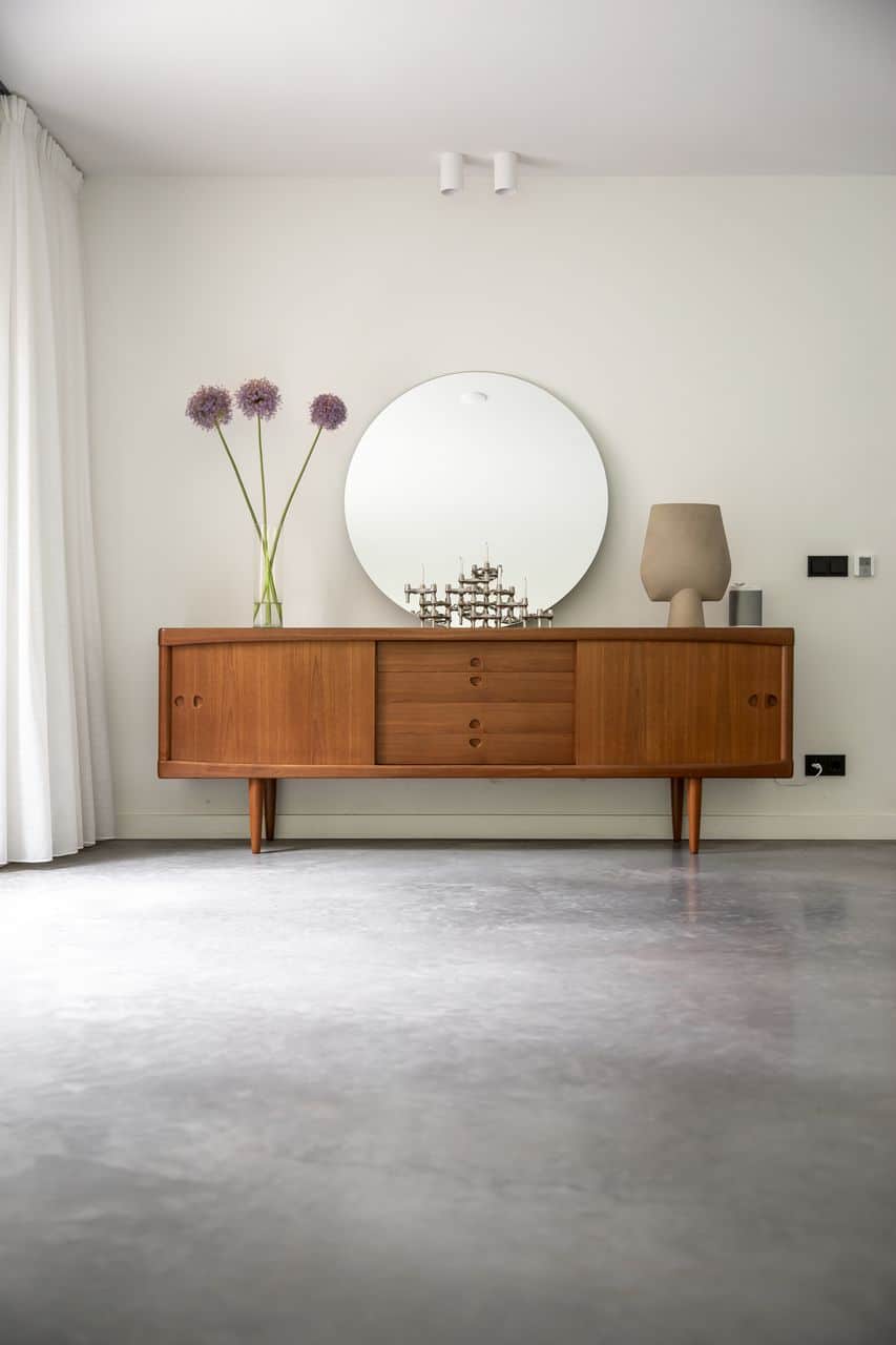 Woning in Epe met een gevlinderde betonvloer met daarop een houten kastje met daarop wat accessoires.