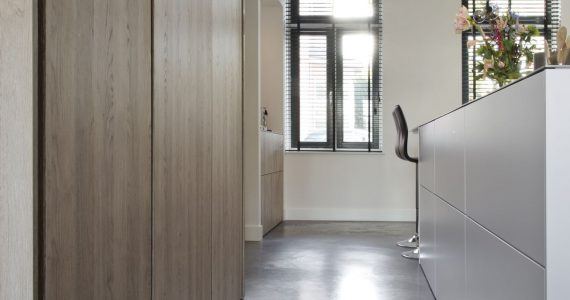 betonvloer in witte woonkeuken
