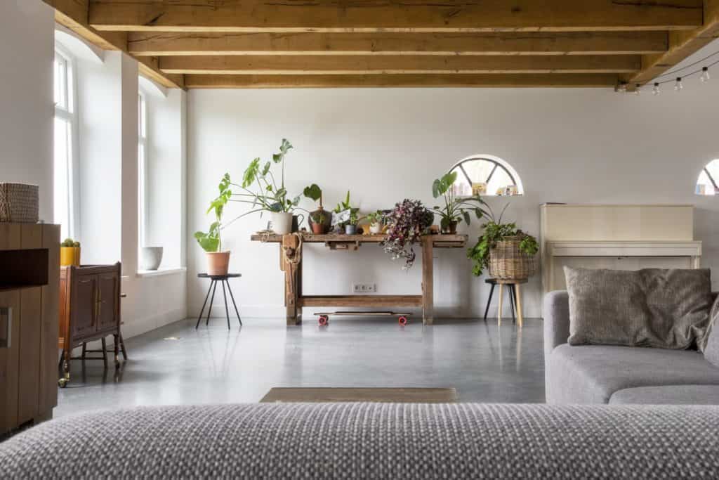Woonkamer met een grijze bank in Schagen gecombineerd met een gevlinderde betonvloer