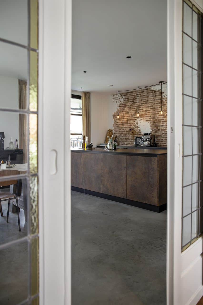 houten vloer vervangen door betonvloer, glas-in-lood-deuren met een industriële keuken